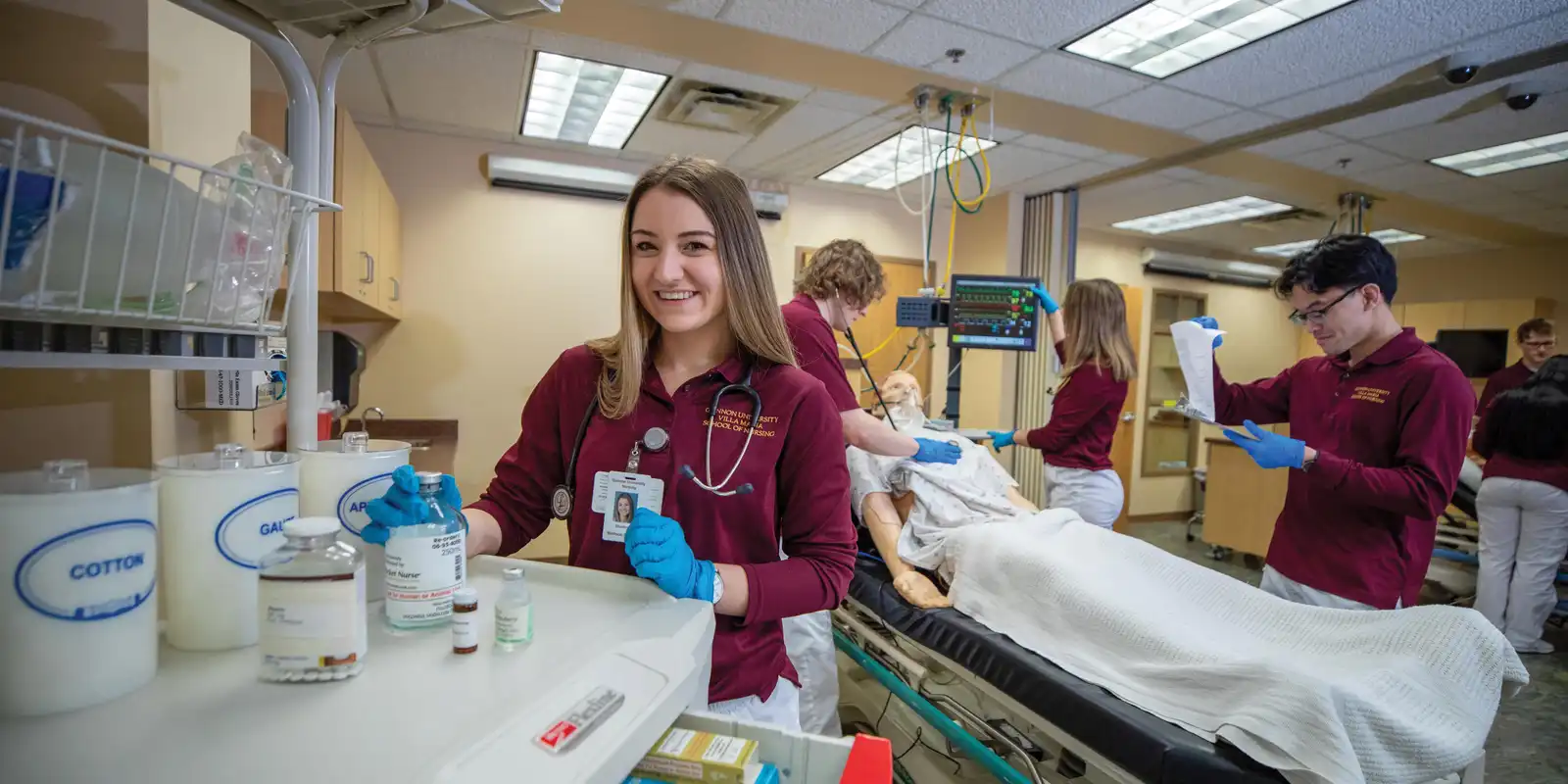 Students in a Bachelor of Science in Nursing program practice hands-on patient care in a simulation lab at a nursing school in Erie, PA