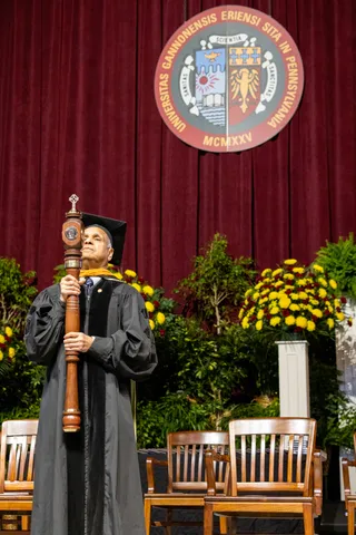 A man holding a mace at ˶ƽ commencement