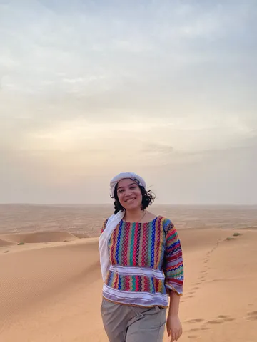 Claudia Herrero Rapagna stands in the Omani desert while on her second Critical Language Scholarship learning intensive in Niwaz, Oman