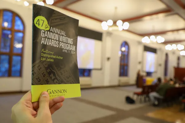 Someone holding the Writing Awards Night program