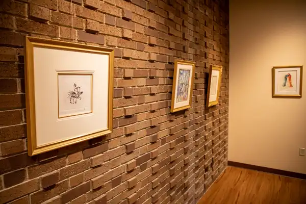 Brick wall with 4 abstract pieces of art in gold frames
