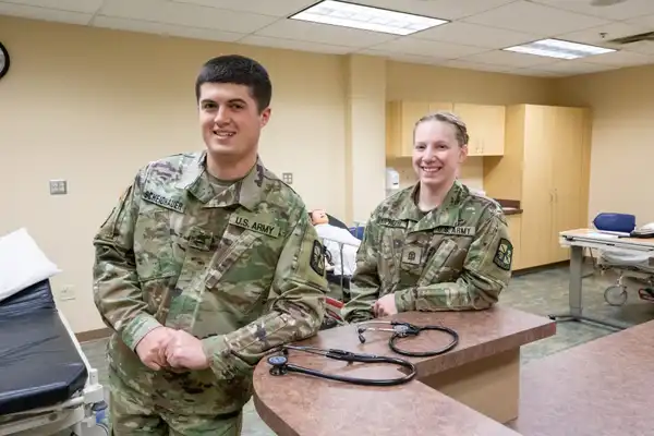 Two students in the Nursing Simulation Lab wearing their Army Uniforms