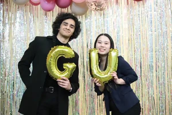 Global students holding a G and U balloon at International Night.