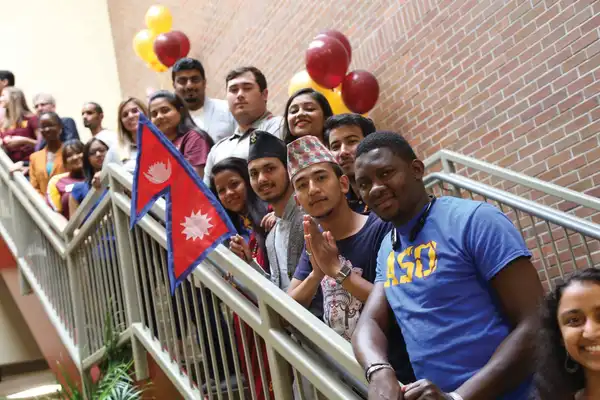 Global Students representing their home country while standing on stairs together
