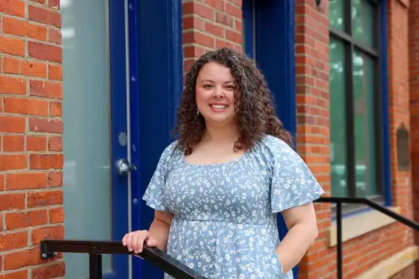 Patrice Swick stands behind a railing on a stairwell in downtown Erie