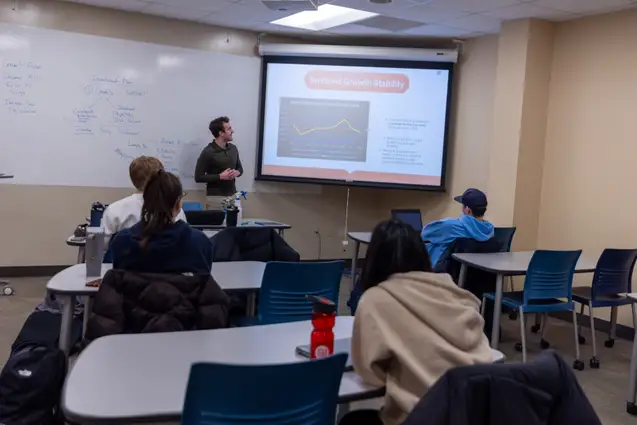 Student presenting in Finance classroom.