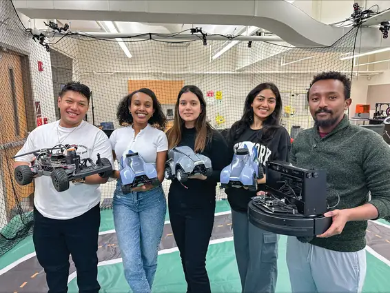 Students displaying robotics and engineering products.