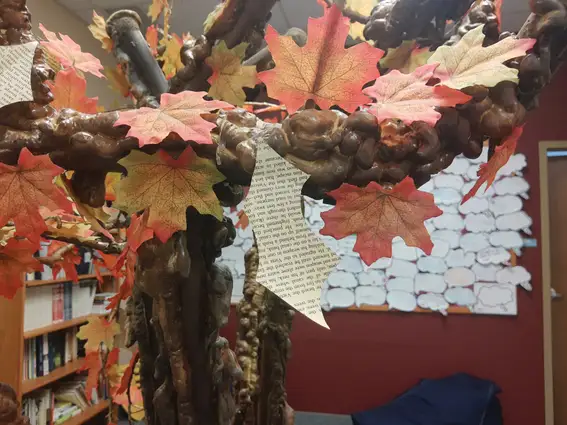 Artificial Tree wit leaves made from paper with typed words on it.