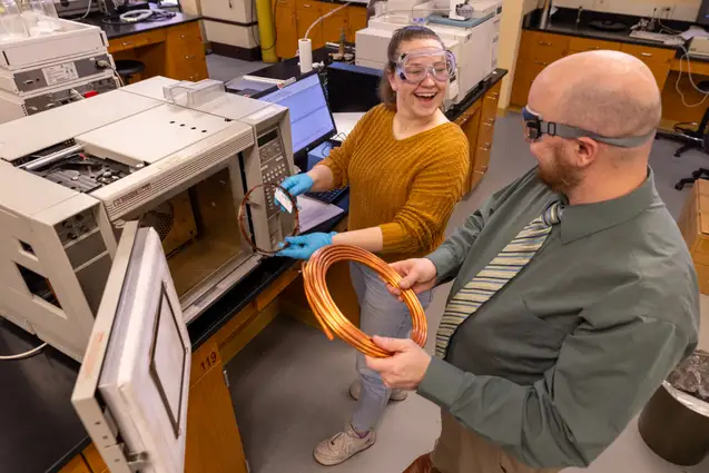 Student and faculty member inside Chemistry lab.