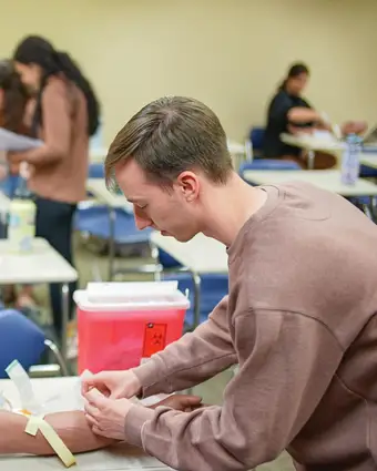 Physician assistant students in Erie Pennsylvania practicing clinical skills in a healthcare lab setting