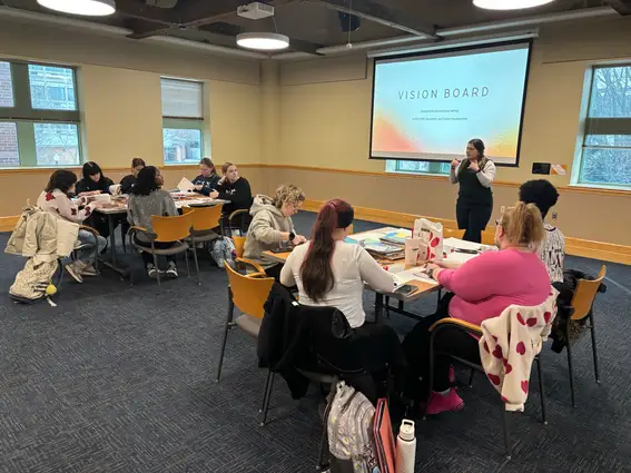 Faculty member giving a presentation on vision boards to a room full of students