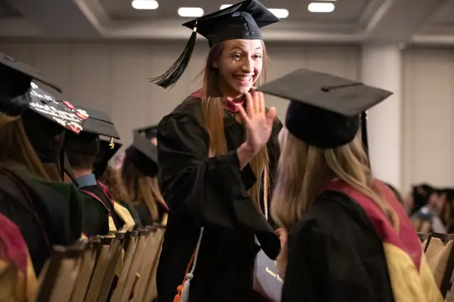 Students high five at the Commencement ceremony at the Tampa Convention Center.