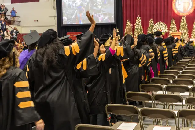 Students lining up to receive diploma.