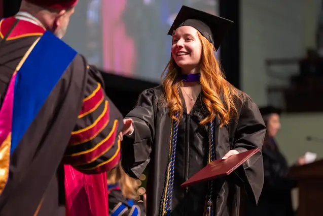 Student receiving a degree at the December Commencement ceremony.