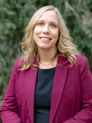 Headshot of Bridget Philip wearing a purple blazer