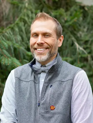 Image of Miles standing outside smiling