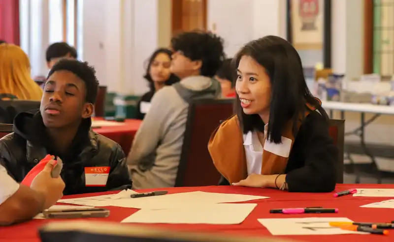 Students talking to eachother at a table