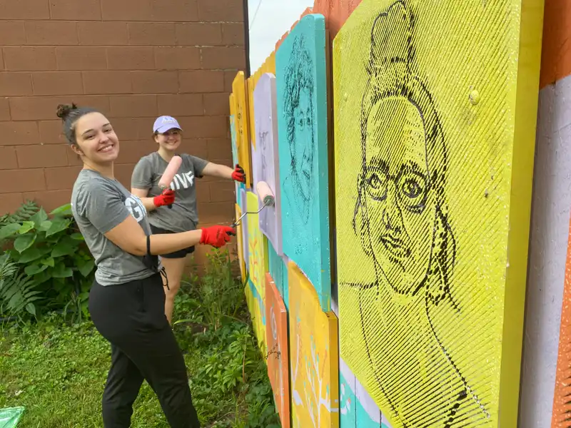 Students painting a fence