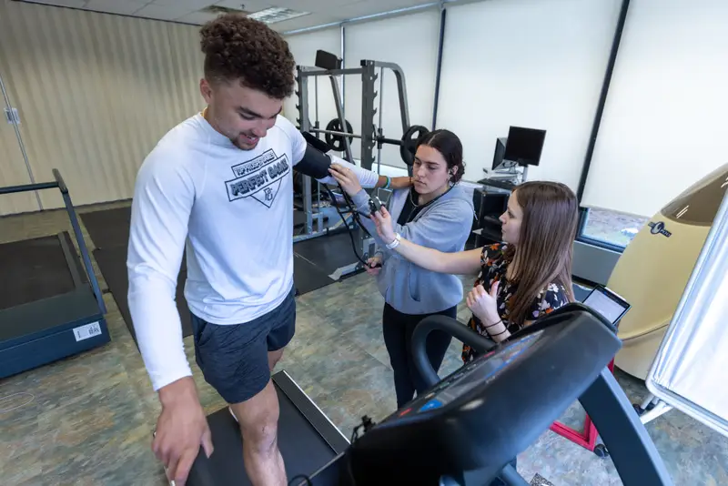 A student walking on a treadmill id examined by students in ����ֱ��'s Applied Exercise Science program