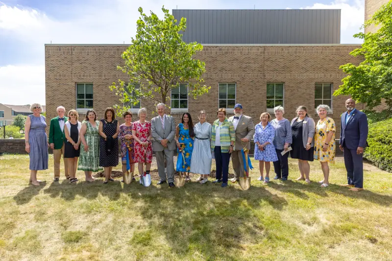 Senior leaders from Gannon University and Ursuline College stand posed around the newly planted Eastern Redbud Tree on Ursuline's campus. symbolizing a new future with Gannon University.