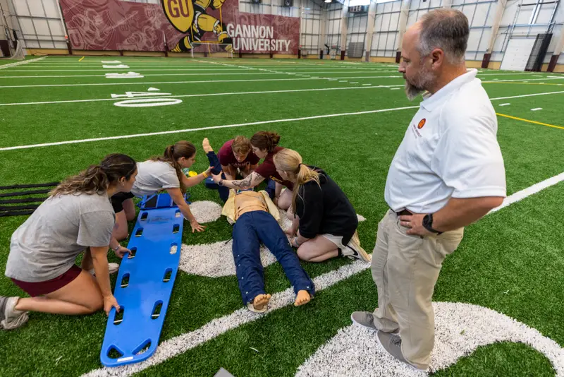 Professor Jorn Roberts mentions students during a training session for the Master of Athletic Training program