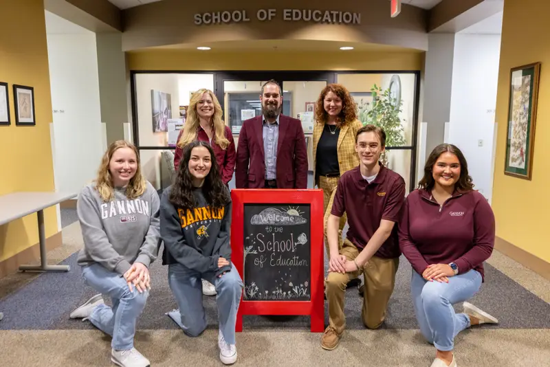 ����ֱ�� Students pose with faculty outside of the university's School of Education