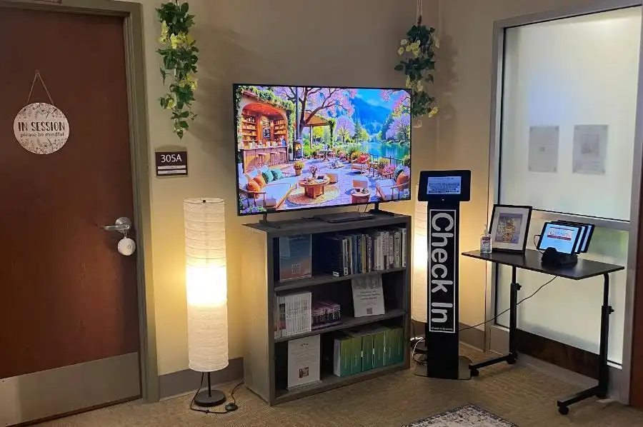 Lobby of the counseling center featuring a relaxing image on a tv and a check in station