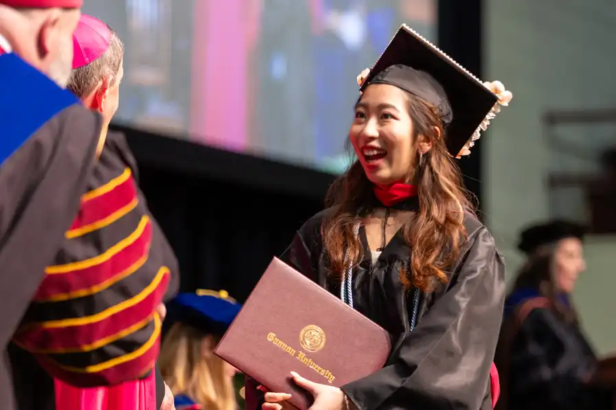Graduate Student receiving degree on stage.